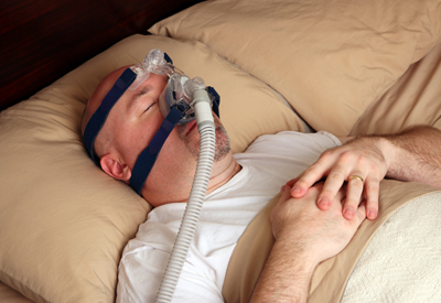 Man sleeping while wearing equipment used for our sleep apnea treatment in Burley, ID